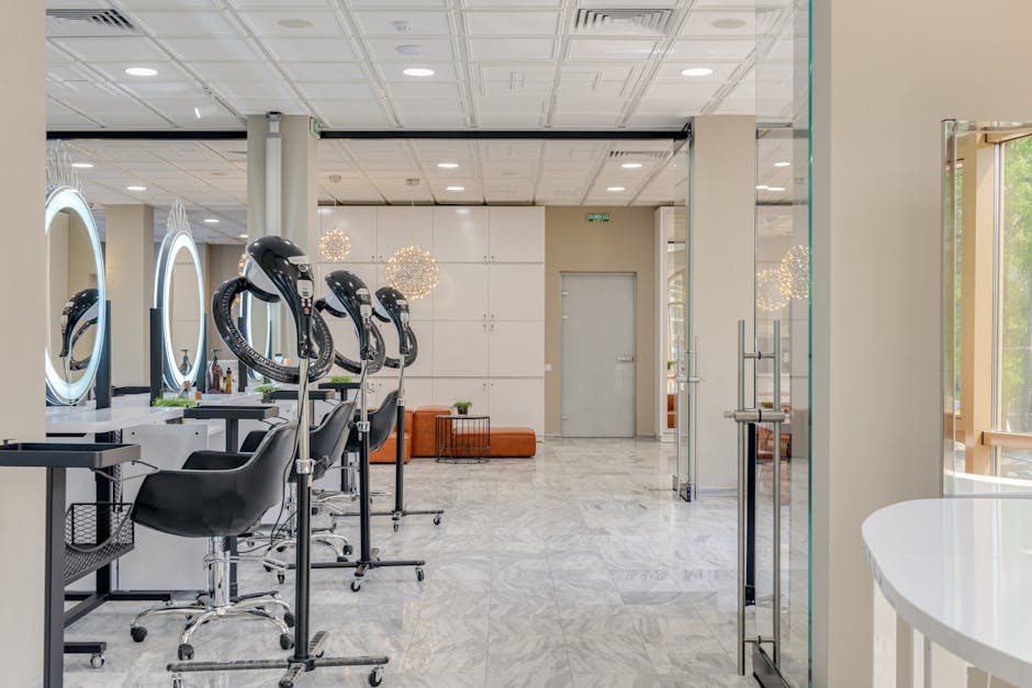 Interno di un moderno salone di bellezza con postazioni di lavoro e asciugacapelli, design che riflette l'evoluzione del MCM nella moda.