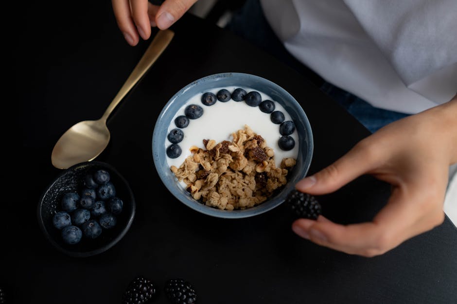 Colazione sana con yogurt, mirtilli e granola, simbolo di un futuro con meno bambini e meno risorse per le scuole a causa del calo demografico.