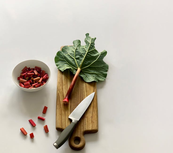 Rabarbaro tagliato su tagliere con coltello e ciotola, ingrediente per calcolare la radice cubica di 729 in cucina.