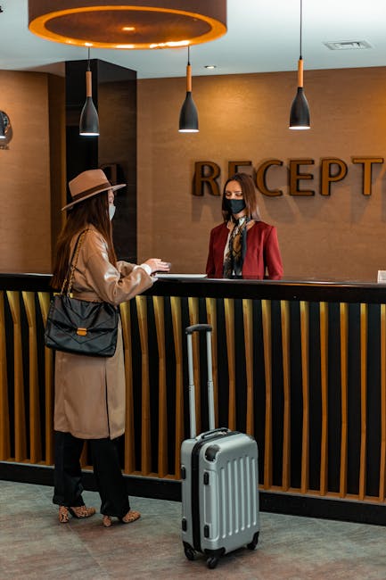 Accoglienza in hotel: cliente con valigia al desk, simbolo di ospitalità e servizio personalizzato per un'esperienza di viaggio indimenticabile.