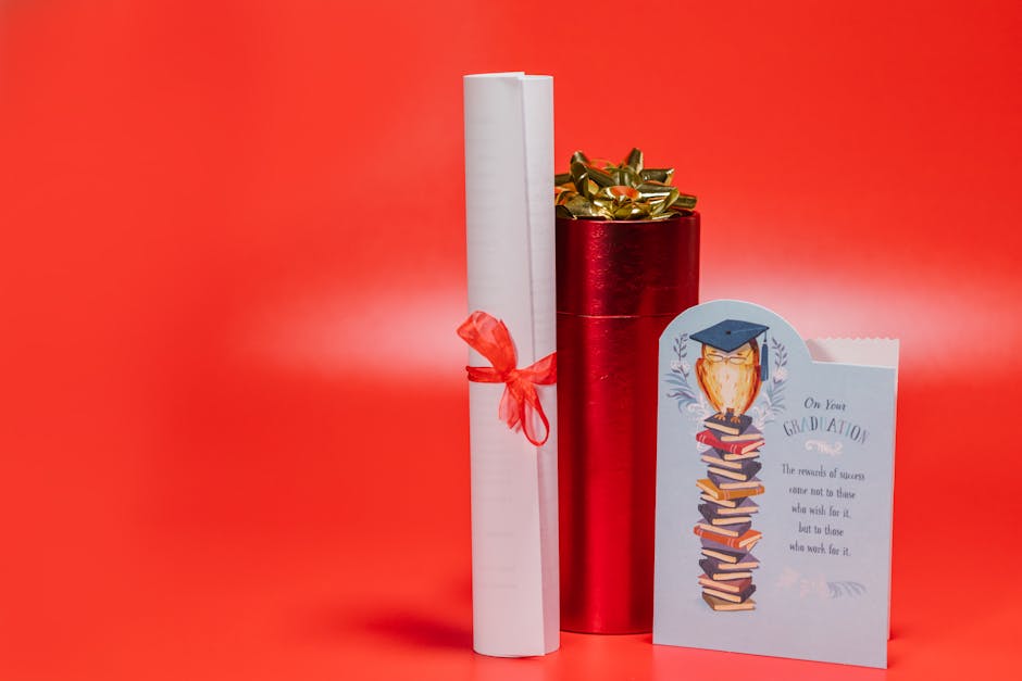 Regalo di laurea con diploma, confezione rossa e biglietto di auguri con gufo laureato su pila di libri, sfondo rosso