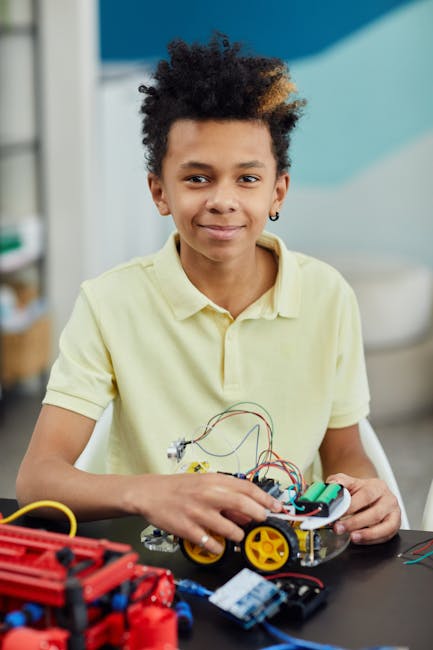 Studente sorridente costruisce robotica a scuola, esempio di apprendimento pratico e innovazione educativa per il futuro.
