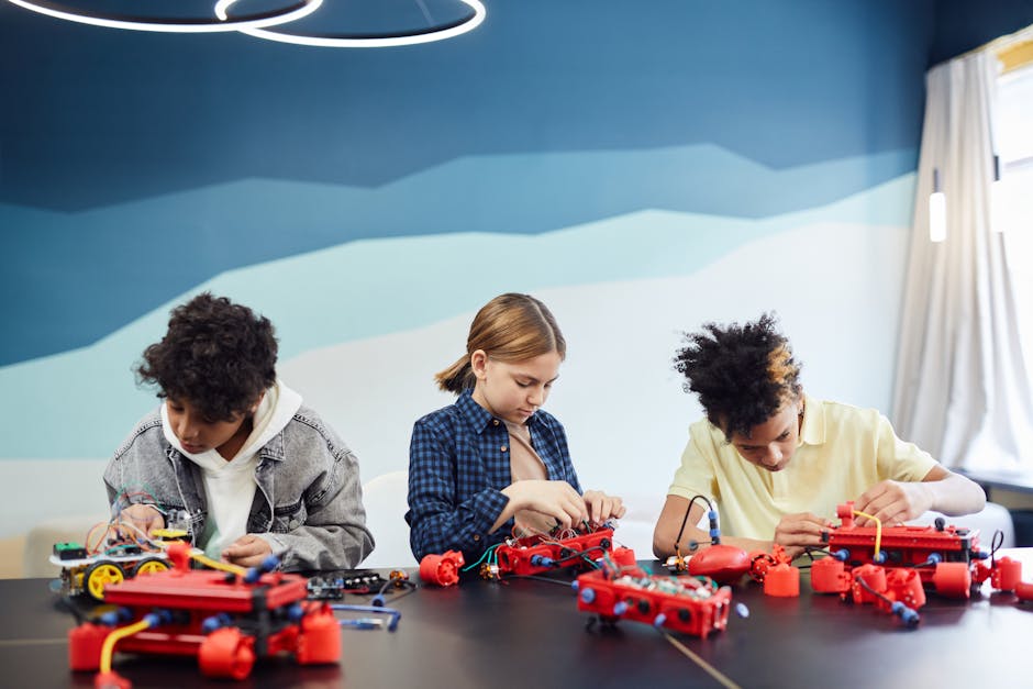 Tre studenti impegnati in un progetto di robotica educativa, un modello innovativo per l'apprendimento STEM e lo sviluppo di competenze pratiche.