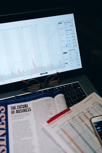 Grafico andamento mercato finanziario su laptop con occhiali e documenti per articolo su margin trading vantaggi e rischi