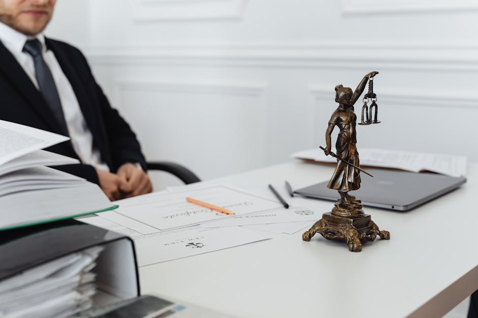 Procedimento disciplinare: avvocato con statua della Giustizia e documenti per la difesa e accesso agli atti del procedimento.