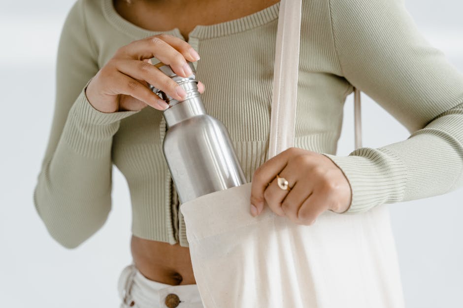 Donna con borraccia riutilizzabile in borsa di tela, stile di vita attivo e sostenibile per raggiungere i tuoi obiettivi di passi giornalieri.