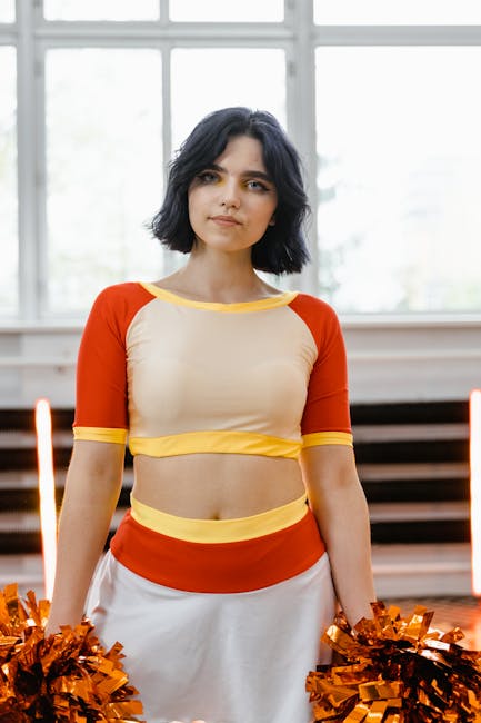 Ragazza cheerleader con pon pon arancioni, esempio di sport extrascolastico per adolescenti e bambini