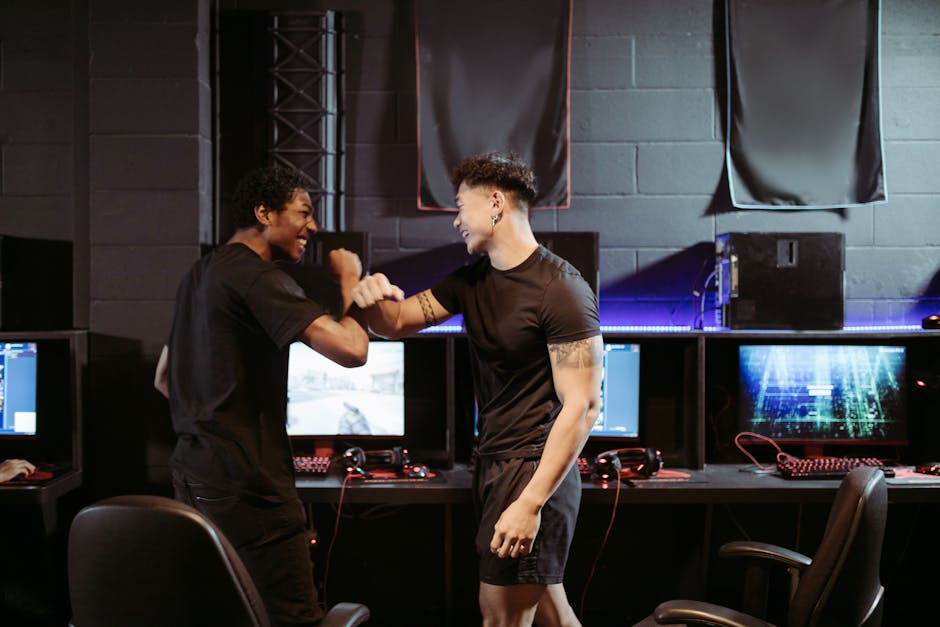 Due giovani gamer esultano davanti ai computer, simbolo di conoscenza computazionale e strategie vincenti nel gaming