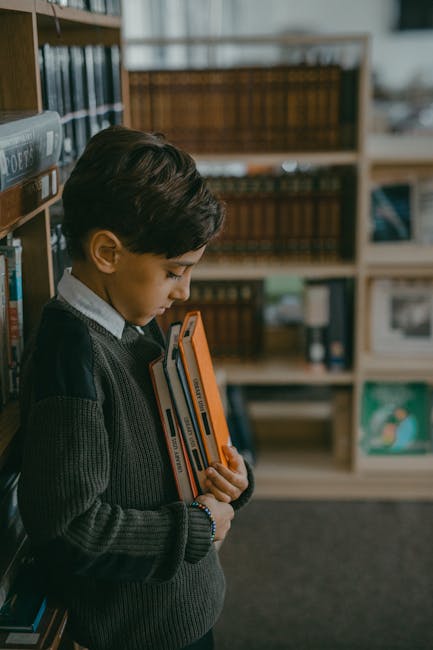 Bambino con libri in biblioteca scolastica, iniziativa io leggo perché per la promozione della lettura e crescita delle biblioteche.