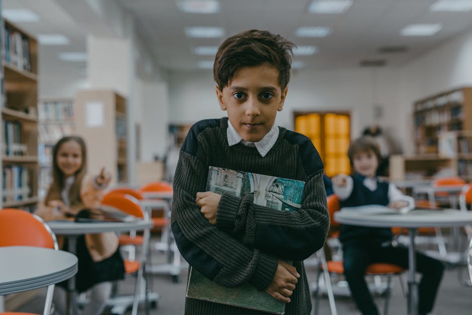 Ragazzo con libro in biblioteca: immagine evocativa di vulnerabilità e bisogno di protezione nel contesto di abusi scolastici.