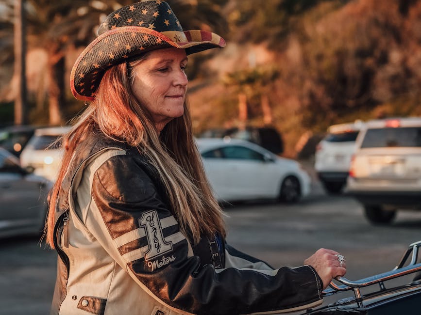 Donna motociclista con cappello da cowboy americano, simbolo di intersezioni culturali e libertà su strada, in un viaggio trasformativo.