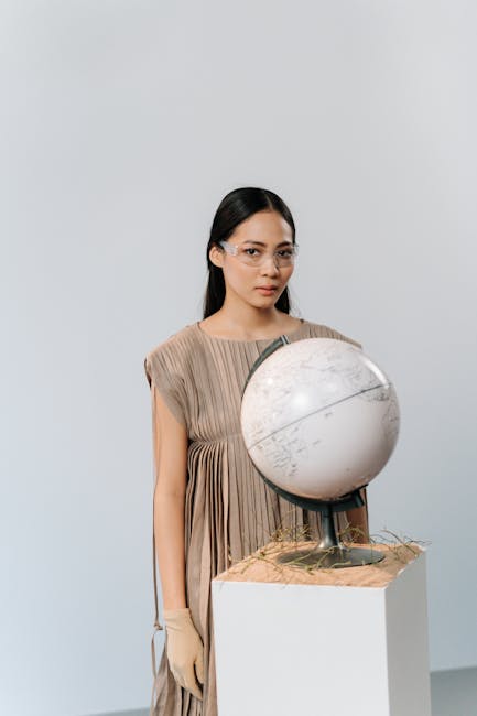 Donna con occhiali e guanti che tiene un globo: metafora di didattica globale, inclusività e innovazione nell'istruzione.