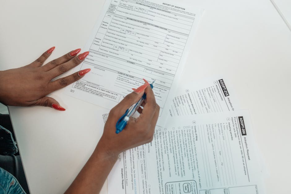 Compilazione accurata domanda PNRR 3: mano che compila modulo adozione, attenzione ai dettagli per evitare errori nel concorso.