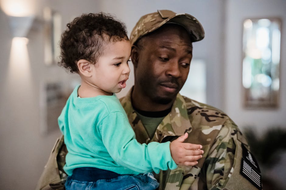 Padre militare tiene in braccio il figlio piccolo a Vittoria RG, in attesa del ritorno in aula dopo il sequestro