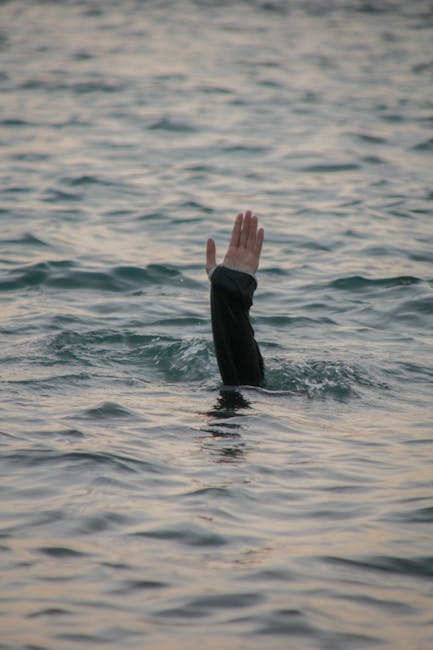 Mano che emerge dall'acqua, metafora dei rischi crescenti dell'intelligenza artificiale e dell'appello di Dario Amodei.
