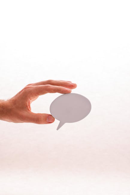 Mano che tiene una nuvoletta di dialogo bianca, simbolo di comunicazione e interazione social, implicazioni per la privacy su Instagram.