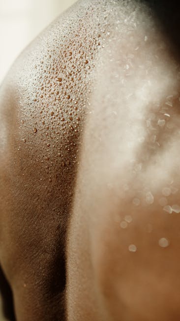 Gocce di sudore sulla pelle scura, simbolo di afa e caldo estivo, strategie per affrontare l'umidità e il benessere fisico.