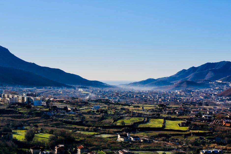 Paesaggio campano con città e montagne sullo sfondo, riflesso della situazione scolastica regionale dopo i tagli alle cattedre di potenziamento.
