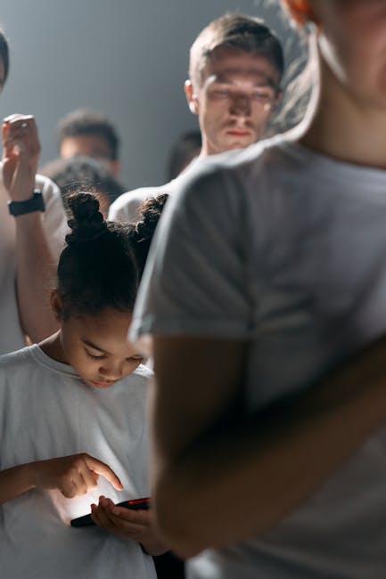 Giovane ragazza usa smartphone in gruppo, rischio dipendenza digitale giovanile, iniziativa Regione Siciliana Lab School contro dipendenze.