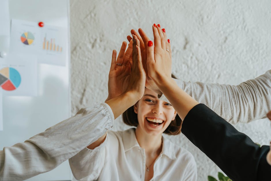 Team di successo celebra il raggiungimento degli obiettivi con un high five, strategie di goal setting per massimizzare il successo personale