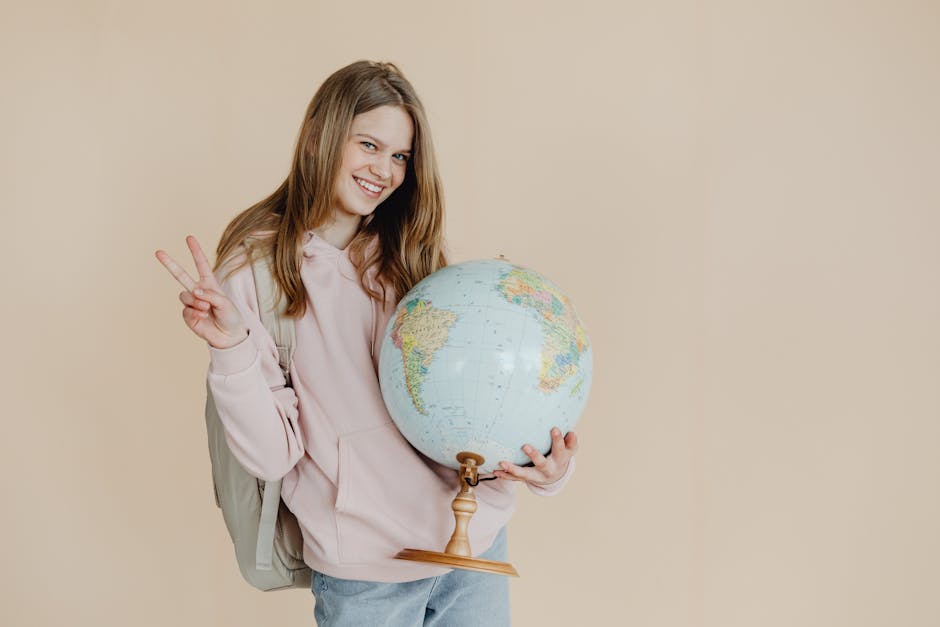 Giovane studentessa sorridente con mappamondo, simbolo dell'impegno globale di Adarsh Kumar e del Global Student Prize 2025.