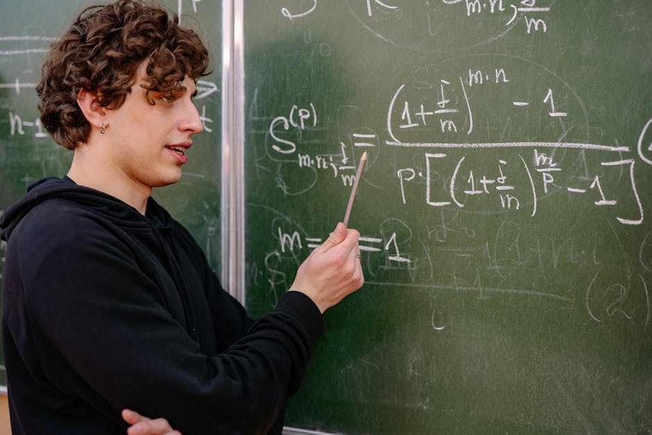 Studente con riccioli castani indica con una matita formule matematiche scritte su una lavagna verde, simbolo di un approccio educativo innovativo.