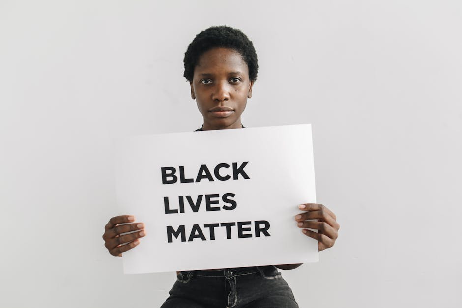 Donna con cartello Black Lives Matter: libertà di espressione e neutralità scolastica nel dibattito pubblico