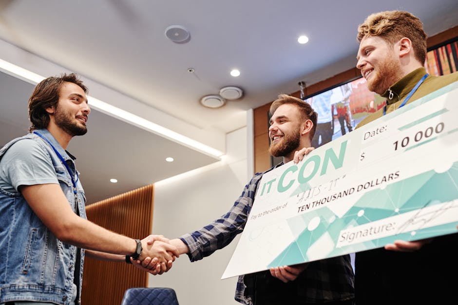 Giovane indiano stringe la mano ricevendo assegno da 10000 dollari per premio globale vinto grazie a autodidattismo e impegno sociale