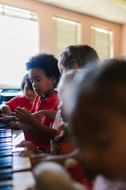 Bambini che suonano il pianoforte a scuola, attività musicale per sviluppare la creatività e l'espressione artistica nei bambini.
