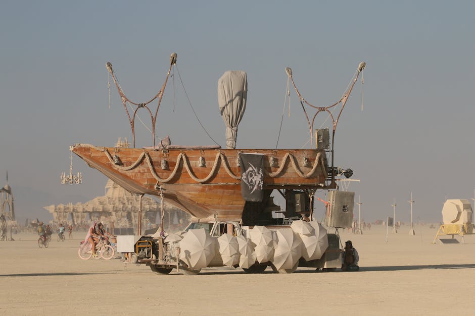 Carro allegorico a forma di nave nel deserto, simbolo di movimento e trasformazione, ispirazione per nuove forme di danza e balli unici.