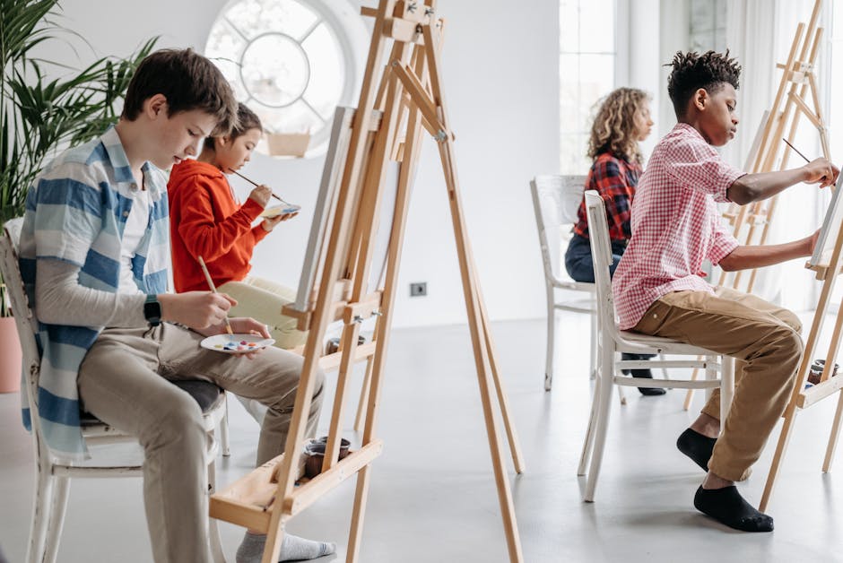 Studenti concentrati che dipingono su cavalletti, un esempio di mindfulness per migliorare l'apprendimento e la concentrazione a scuola.