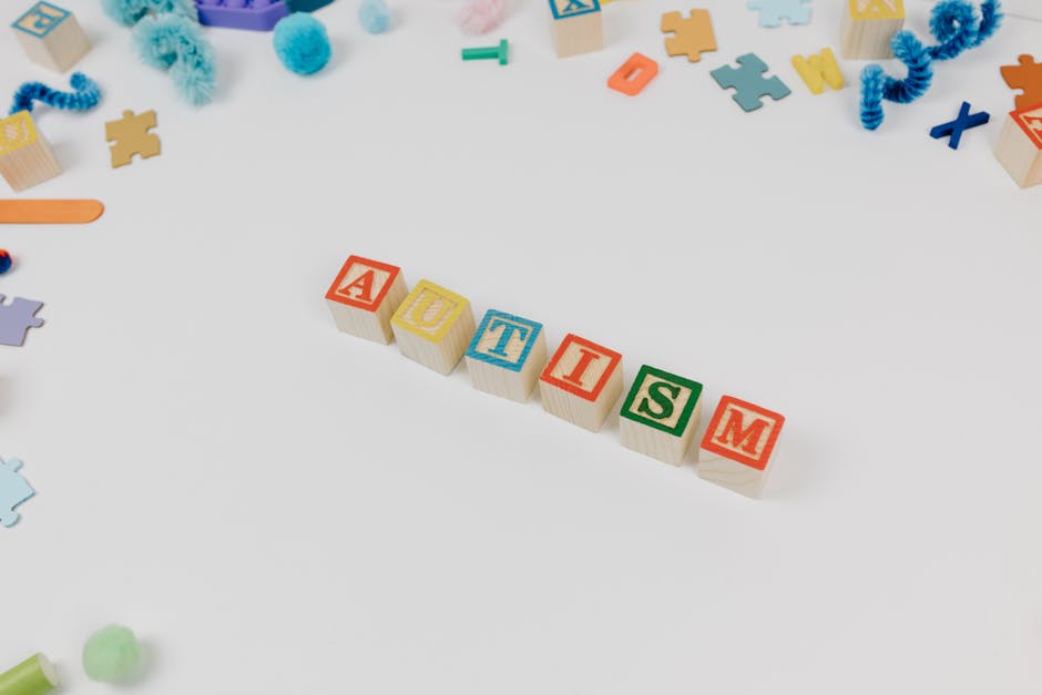 Cubetti colorati con la parola AUTISMO e giochi sparsi, elementi di gioco per la gamification educativa e l'apprendimento inclusivo.