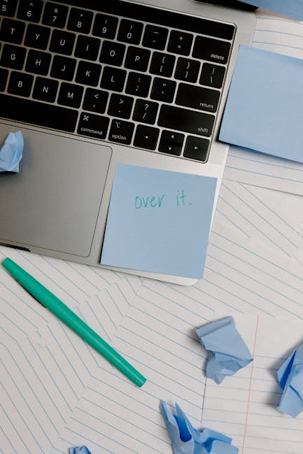 Laptop con post-it 'over it' e fogli accartocciati, simbolo di frustrazione per le iscrizioni scolastiche 2026 e le scelte post-diploma