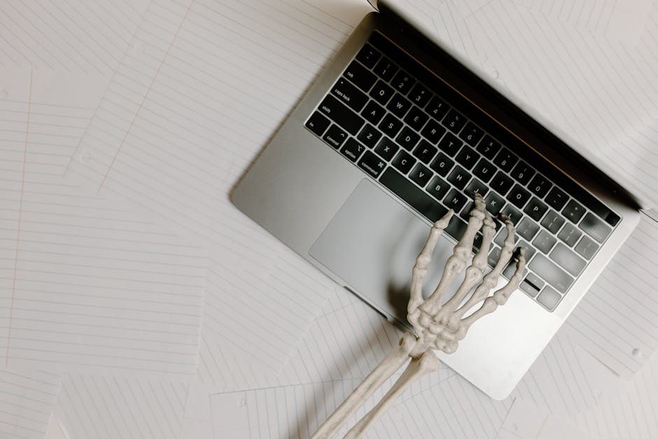 Scheletro che digita su un laptop, metafora del lavoro eccessivo nei consigli scolastici e della loro importanza per l'istruzione