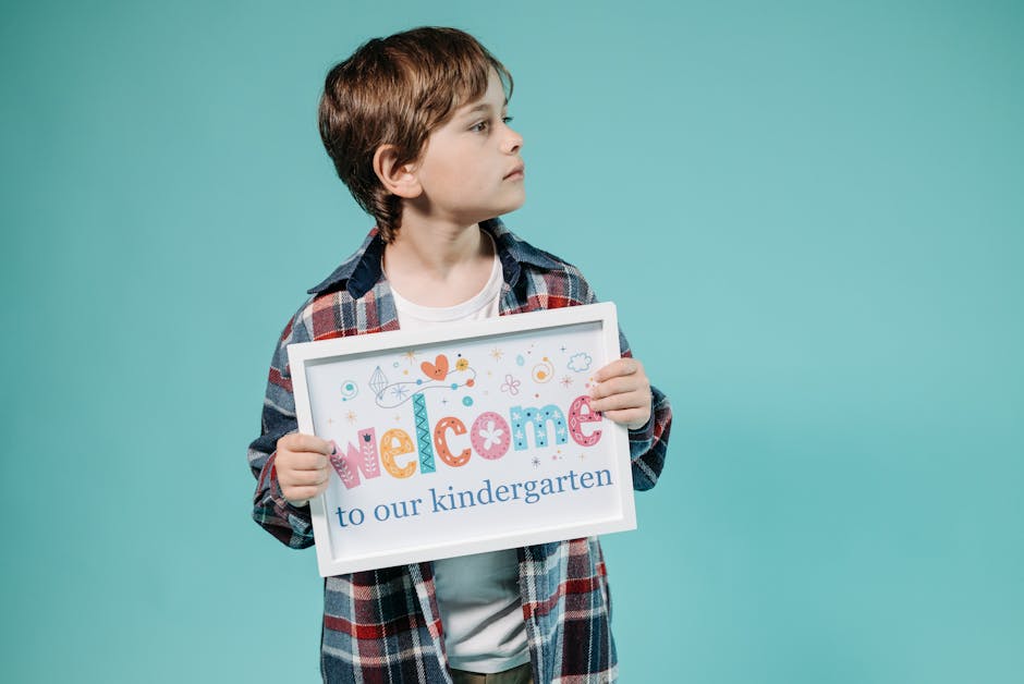Bambino con cartello Welcome to our kindergarten. Iscrizioni scuola primaria 2026/27. Domanda di iscrizione scuola elementare.