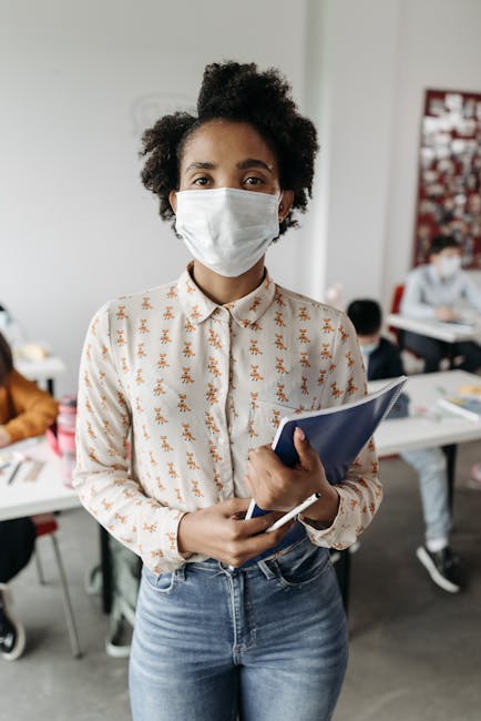 Insegnante con mascherina in aula: importanza dell'educazione stradale per i giovani e la prevenzione degli incidenti durante le lezioni.