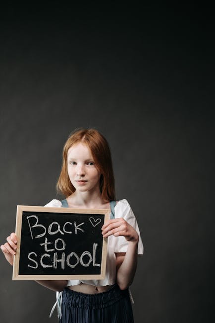 Bambina con lavagna 'Back to School' dopo trapianto: simbolo di speranza e ritorno alla normalità dopo il delicato intervento.