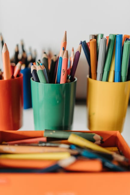 Materiale didattico colorato per insegnanti: matite, pennarelli e contenitori per un feedback costruttivo in classe.