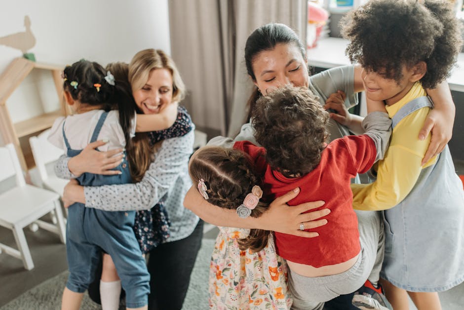 Educatrici abbracciano bambini: importanza dell'educazione affettiva e sessuale per lo sviluppo sano dei giovani studenti