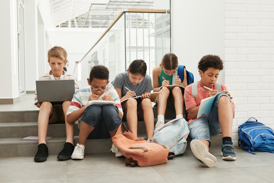 Studenti seduti sulle scale che studiano con libri e computer, contesto scolastico dopo la tragedia del collaboratore