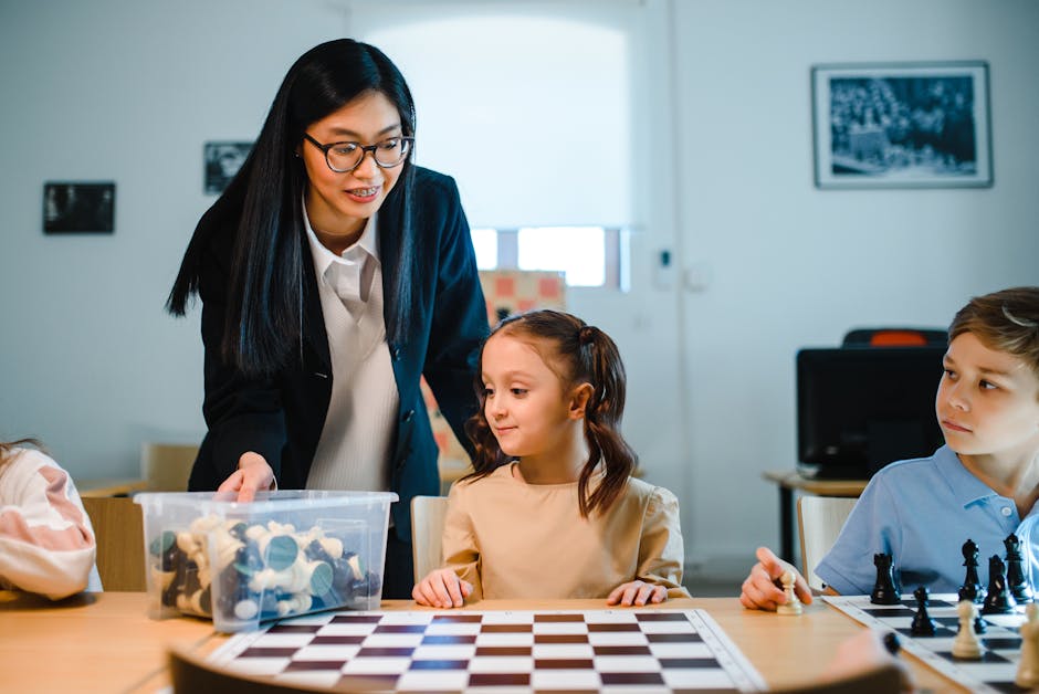 Docente spiega il gioco degli scacchi a bambini in classe, strumento didattico per l'analisi critica e la prevenzione dell'emulazione ideologica.