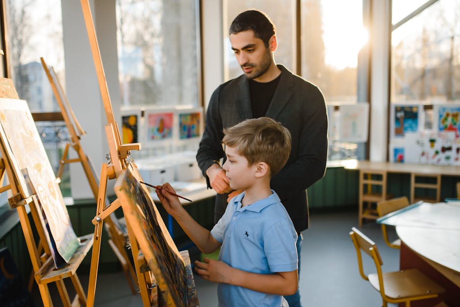 Docente supplente art 47 assiste alunno durante lezione di pittura, ambiente scolastico luminoso e accogliente, focus su apprendimento e creatività.