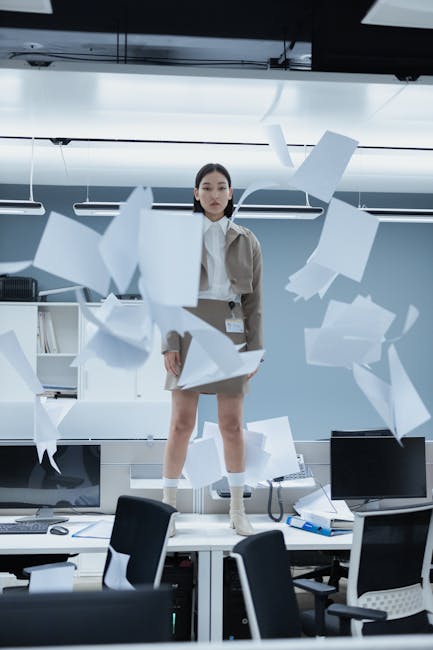 Donna in ufficio con documenti volanti: scopri la potenza degli elaborati su Indire per semplificare il lavoro e aumentare la produttività.