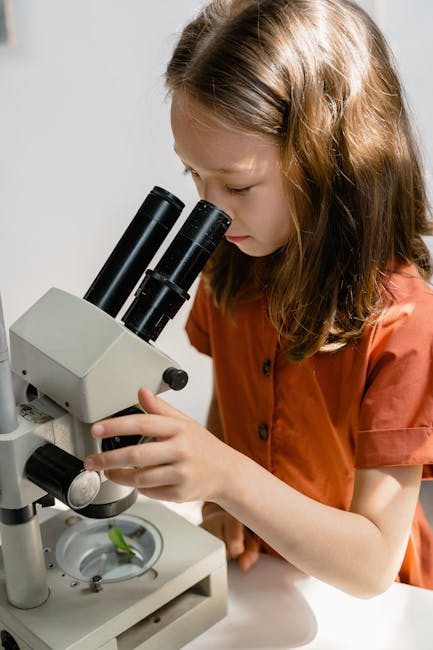 Bambina che usa il microscopio per esperimenti scientifici, stimolando la curiosità e l'apprendimento attivo in modo coinvolgente