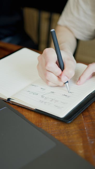 Mano che scrive su un quaderno a righe, ideale per etichette adesive personalizzate per quaderni e organizzazione scolastica.
