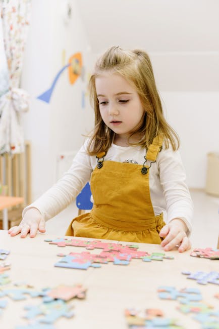 Bambina che gioca con puzzle: sviluppo cognitivo e importanza dell'educazione infantile per la crescita e la socializzazione.