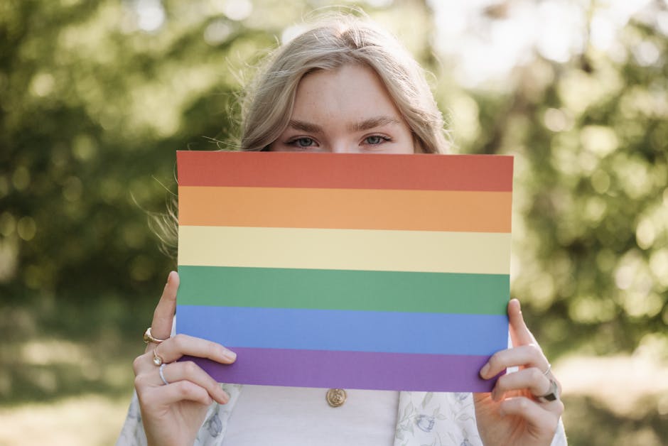 Giovane donna con bandiera arcobaleno simbolo dei diritti LGBTQ+ per la pace e la libertà, valori promossi da Laura Boldrini