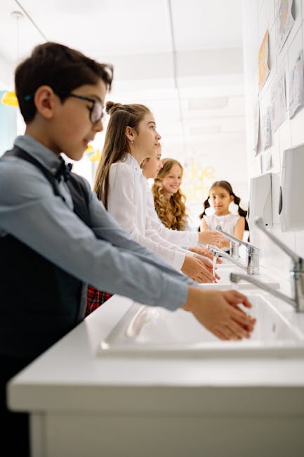 Giornata mondiale igiene mani: studenti si lavano le mani a scuola per prevenire batteri resistenti, focus su banchi e schermi puliti.