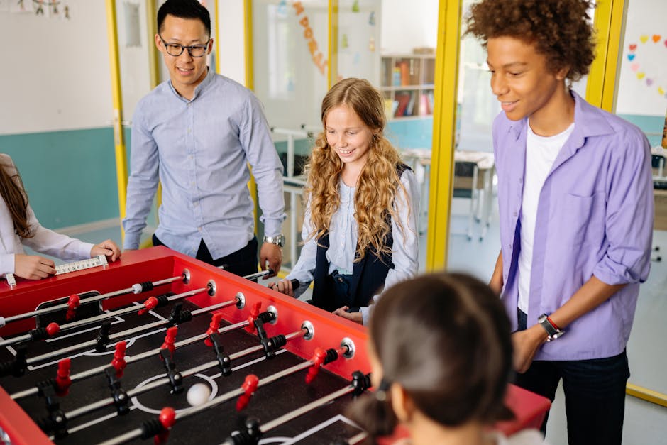 Docenti e studenti giocano a calcio balilla in classe, ambiente scolastico inclusivo e motivante per il concorso PNRR3