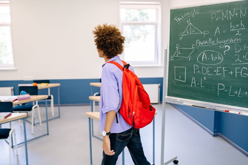 Studente con zaino rosso in aula di matematica all'Università di Pisa, lavagna con formule e geometria, corsi Fosche.